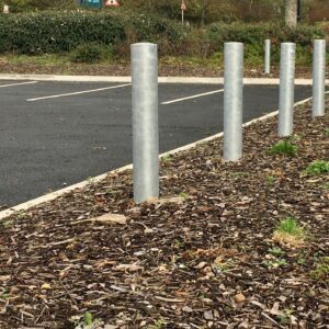 A row of Galvanised Plain Round Bollard 1000mm Concreted in around a car park