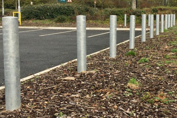 A row of Galvanised Plain Round Bollard 1000mm Concreted in around a car park