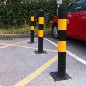 Galvanised High-Vis Black and Yellow Bollard Concrete In, positioned in a car park